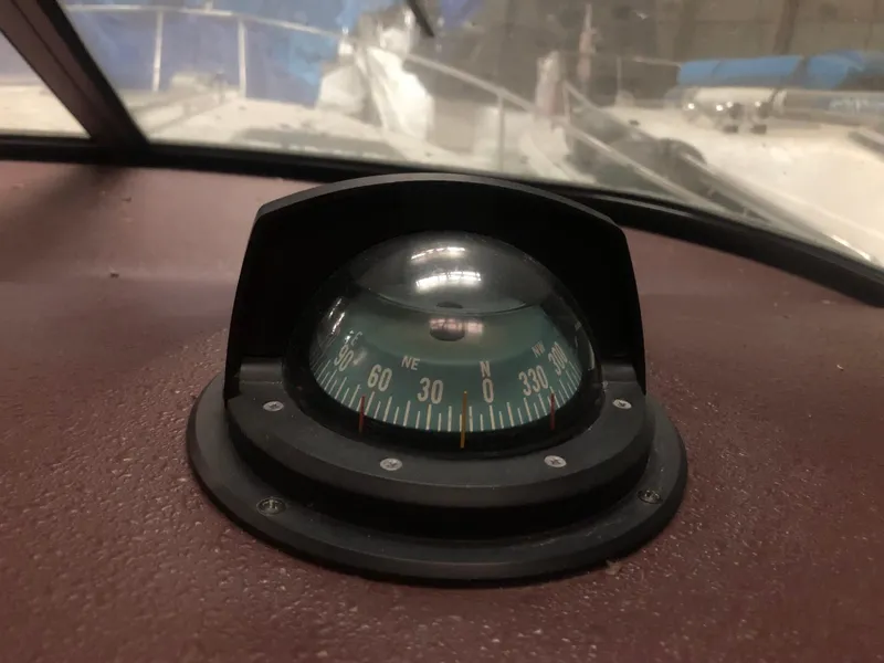 Slide: The Image of Compass on 1989 Sea Ray 280 Sundancer boat dashboard, showing navigation directions. - 35
