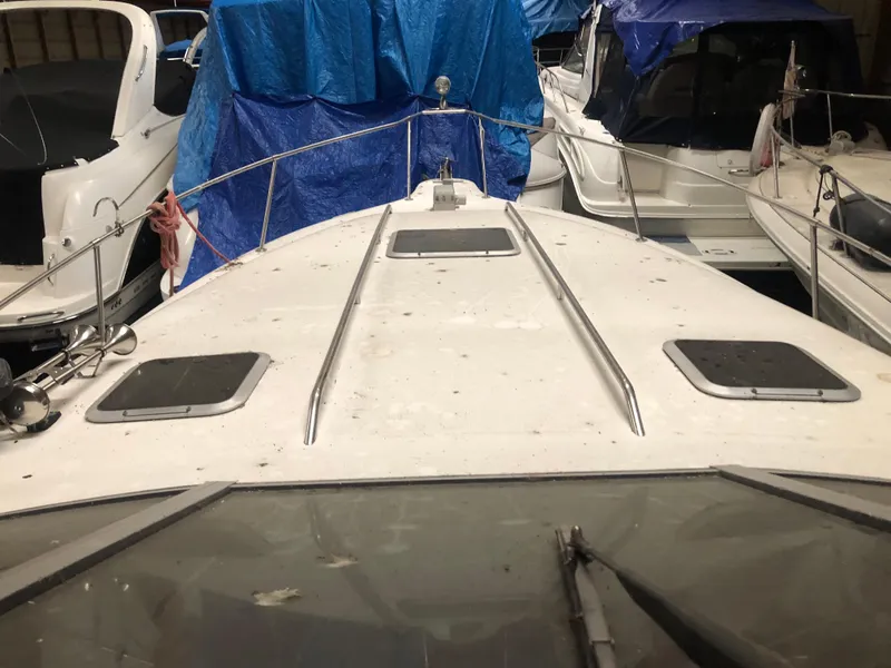 Slide: The Image of 1989 Sea Ray 280 Sundancer boat docked, covered with tarps, surrounded by other boats. - 38