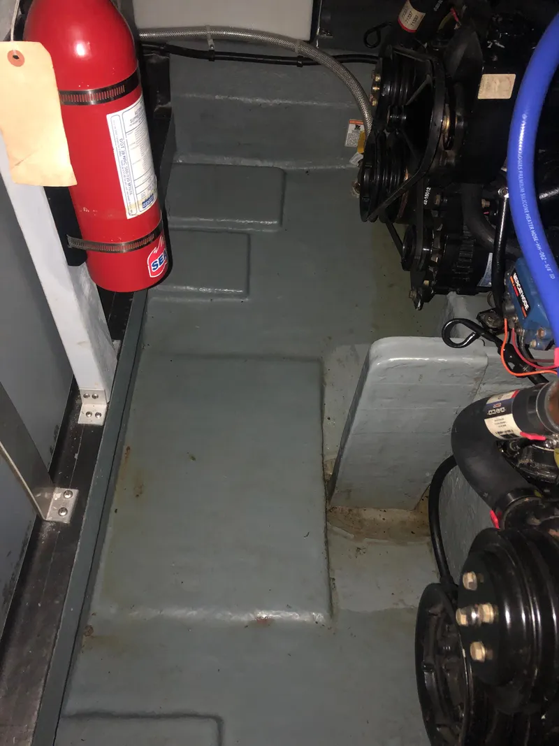 Slide: The Image of Engine compartment of 1989 Sea Ray 280 Sundancer with fire extinguisher and visible machinery. - 44