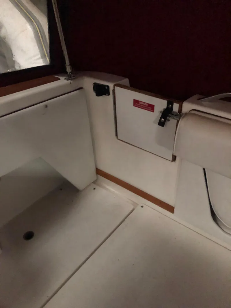 Slide: The Image of 1989 Sea Ray 280 Sundancer interior with white seating and storage compartments. - 49
