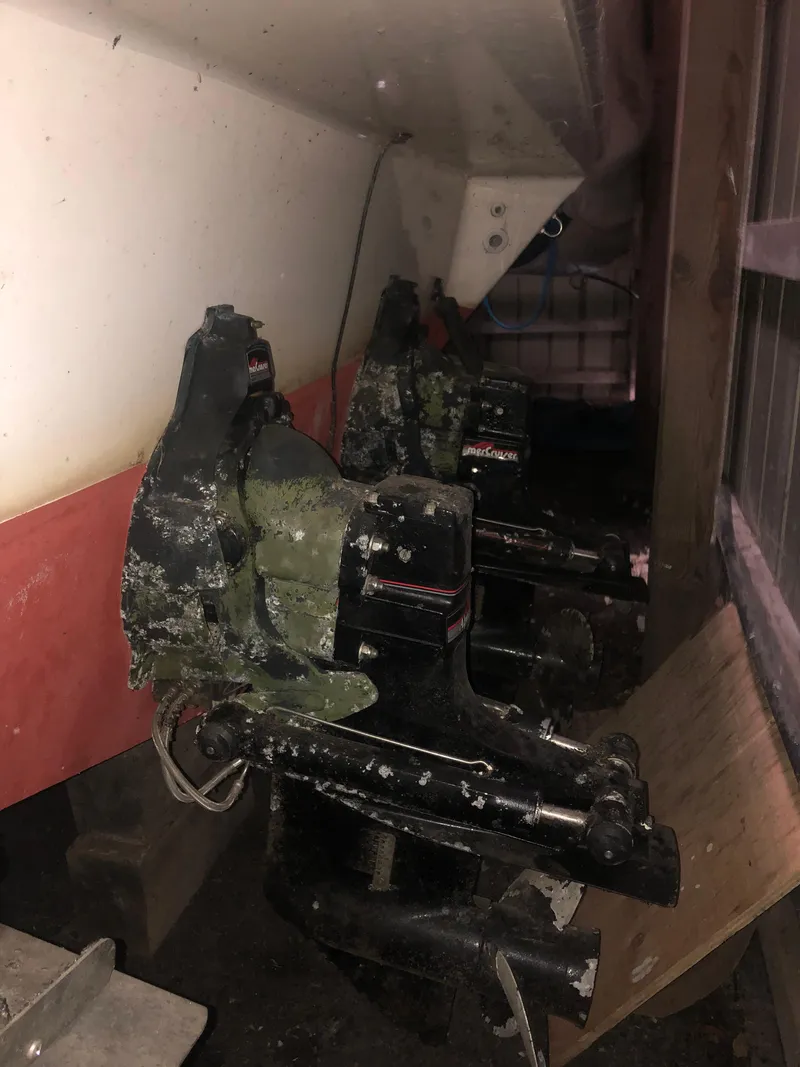 Slide: The Image of 1989 Sea Ray 280 Sundancer boat engines with visible wear and marine growth. - 6