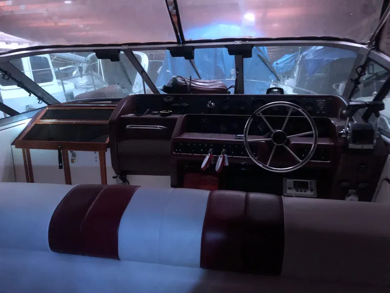 Slide: The Image of 1989 Sea Ray 280 Sundancer boat cockpit with steering wheel and dashboard controls. - 7