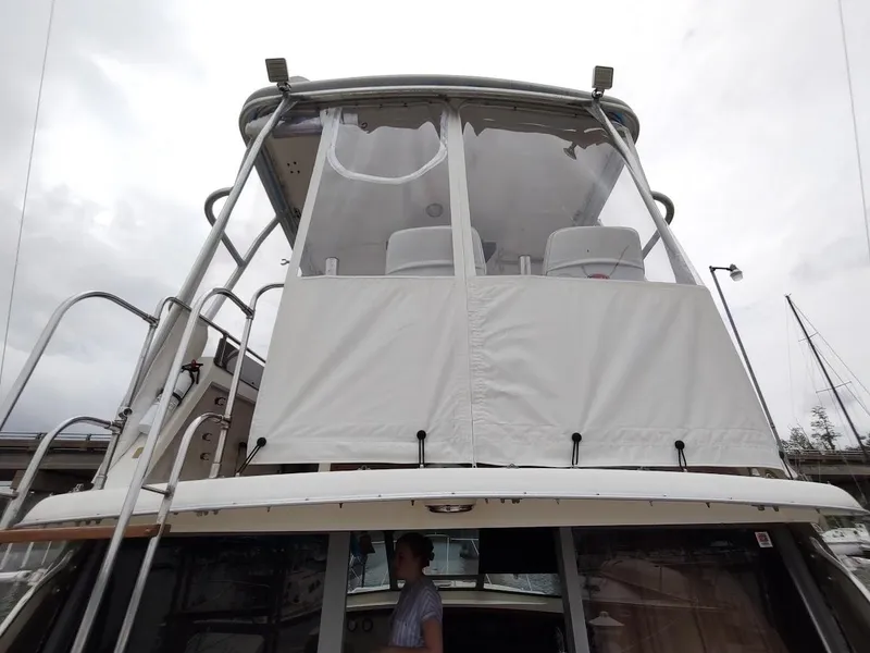 Slide: The Image of 1988 Trojan F32 Sedan boat with enclosed upper deck, docked at marina. - 13