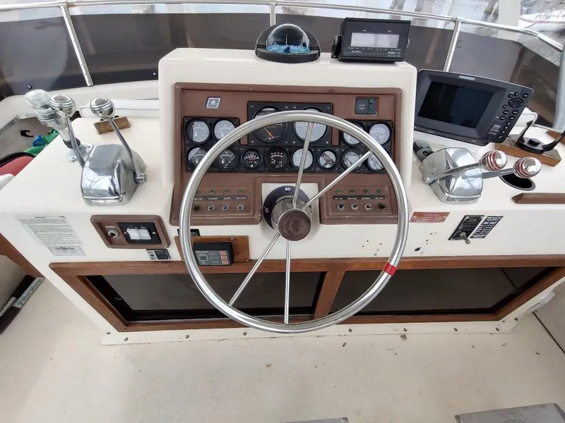 Slide: The Image of 1988 Trojan F32 Sedan boat helm with steering wheel, gauges, and navigation equipment. - 17