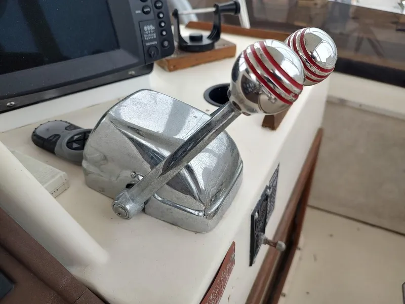 Slide: The Image of 1988 Trojan F32 Sedan boat throttle controls with chrome levers and red accents. - 18
