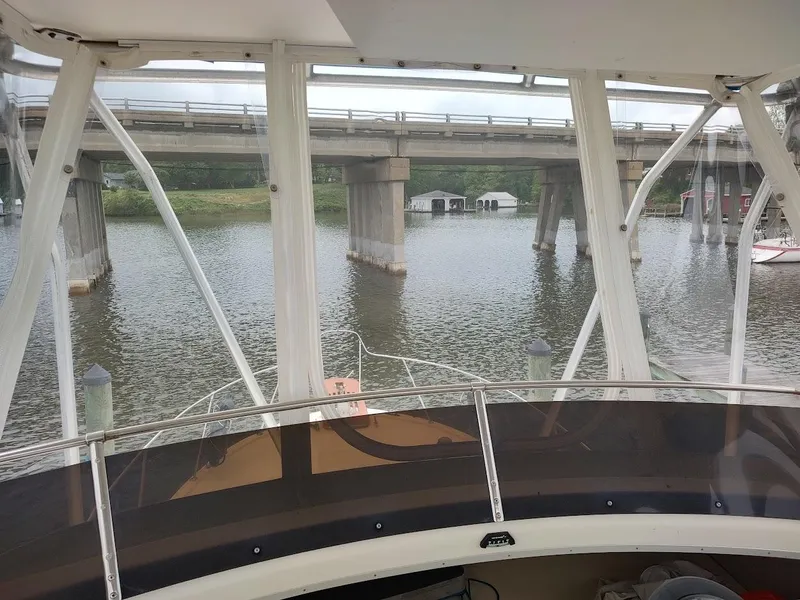 Slide: The Image of 1988 Trojan F32 Sedan boat view under a bridge on a calm river. - 27