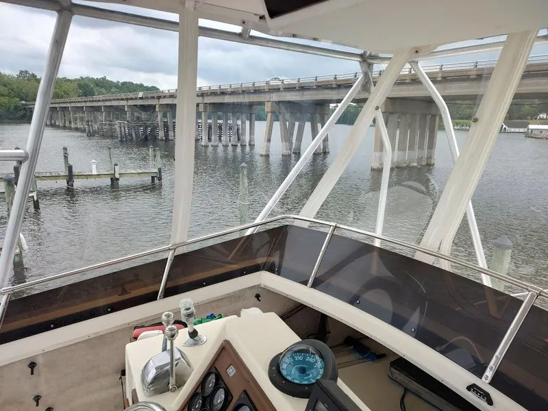 Slide: The Image of 1988 Trojan F32 Sedan boat interior with bridge view over calm water. - 29