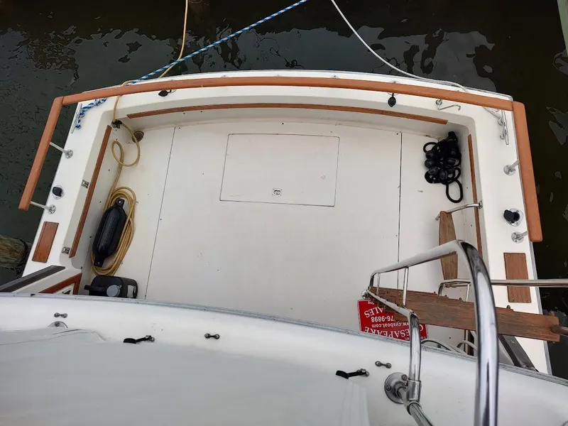 Slide: The Image of 1988 Trojan F32 Sedan boat deck with wooden railings and nautical equipment. - 32