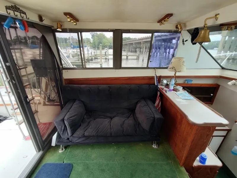 Slide: The Image of Interior of a 1988 Trojan F32 Sedan boat with a cozy seating area and waterfront view. - 36