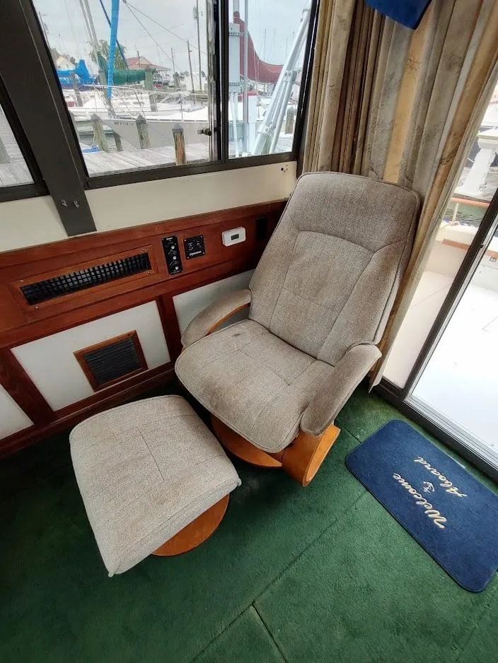Slide: The Image of Comfortable seating in a 1988 Trojan F32 Sedan boat interior with marina view. - 38