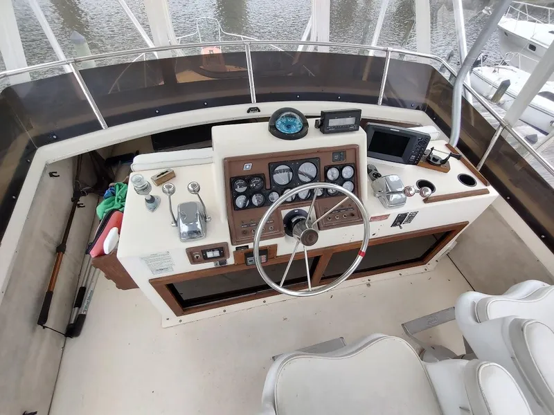 Slide: The Image of 1988 Trojan F32 Sedan boat helm with steering wheel, gauges, and navigation equipment. - 14
