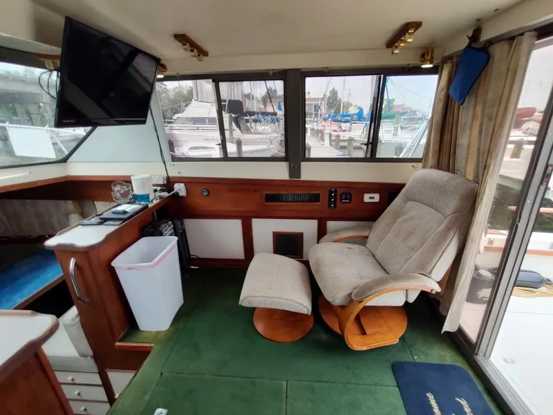 Slide: The Image of Interior of a 1988 Trojan F32 Sedan boat with recliner and TV. - 37