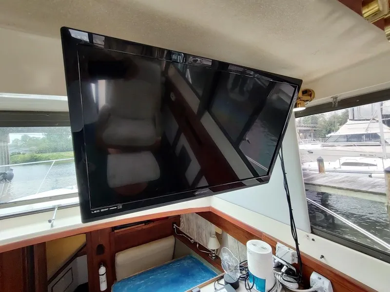 Slide: The Image of Interior of 1988 Trojan F32 Sedan with mounted flat-screen TV and marina view. - 39