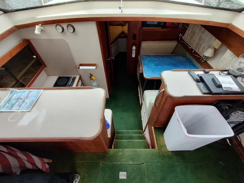 Slide: The Image of Interior of a 1988 Trojan F32 Sedan boat with green carpet and wooden furnishings. - 44