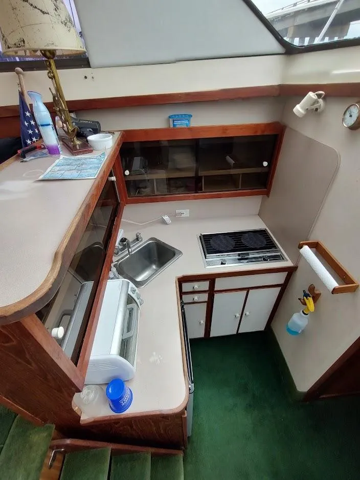 Slide: The Image of 1988 Trojan F32 Sedan boat kitchen with stove, sink, and storage cabinets. - 45