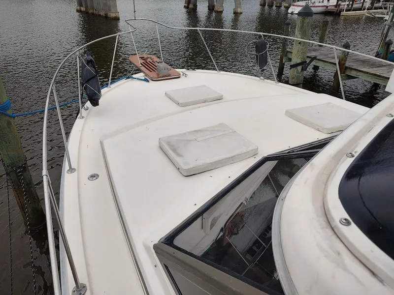 Slide: The Image of 1988 Trojan F32 Sedan boat deck at marina, featuring hatches and railing. - 5