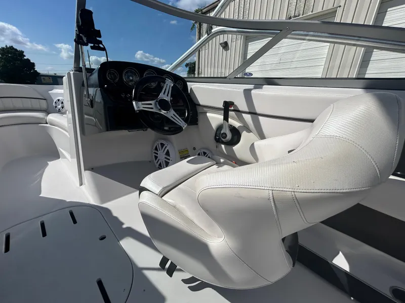 Slide: The Image of 2010 Four Winns H210 boat interior with white captain's chair and steering wheel. - 11
