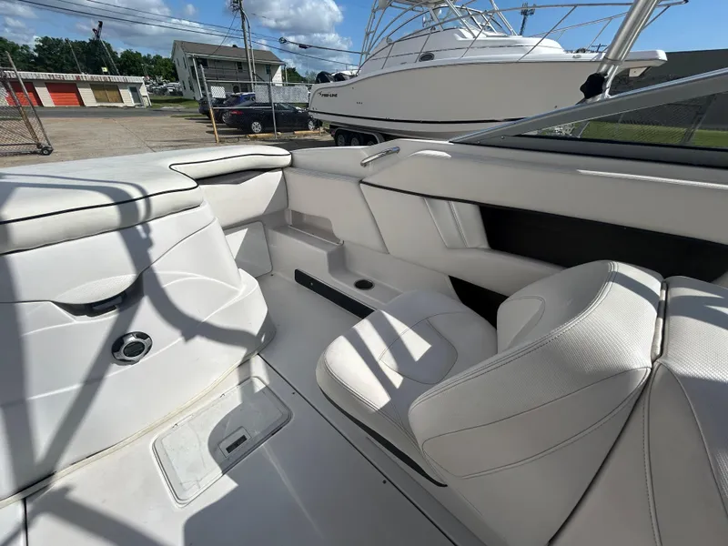 Slide: The Image of Interior of a 2010 Four Winns H210 boat with white seating and storage compartments. - 13