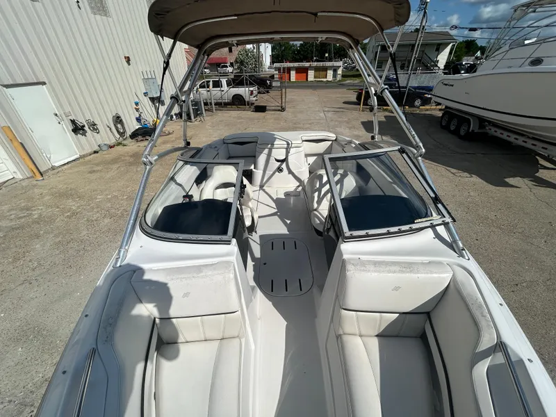 Slide: The Image of 2010 Four Winns H210 boat interior with seating and canopy in a marina. - 17