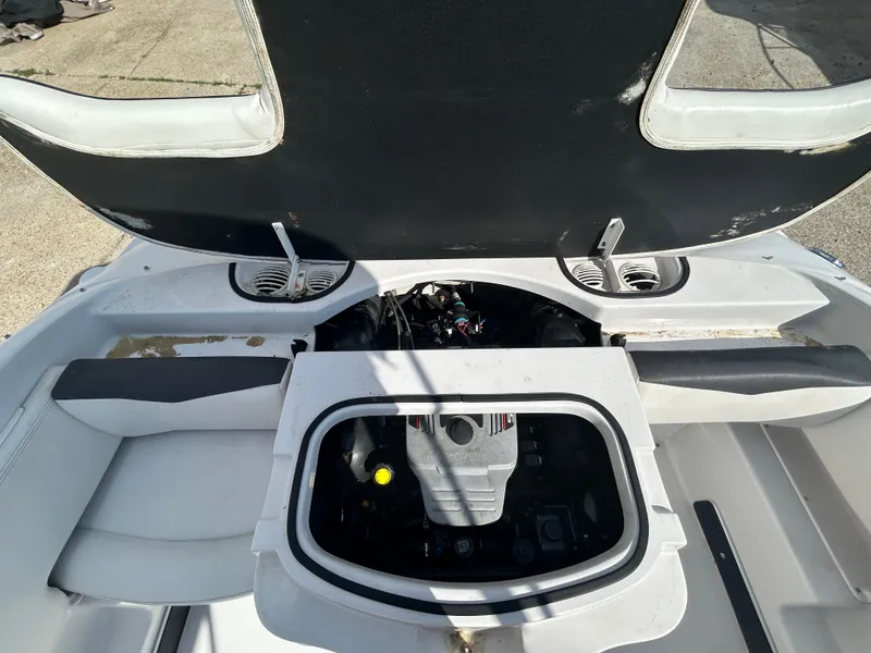 Slide: The Image of 2010 Four Winns H210 boat with open engine compartment and seating area. - 19