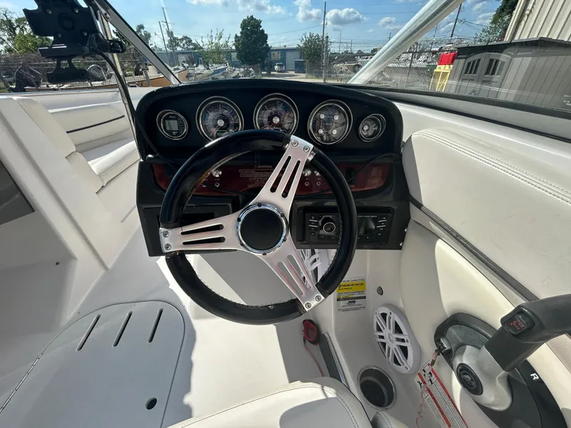 Slide: The Image of 2010 Four Winns H210 boat dashboard with steering wheel and gauges. - 20