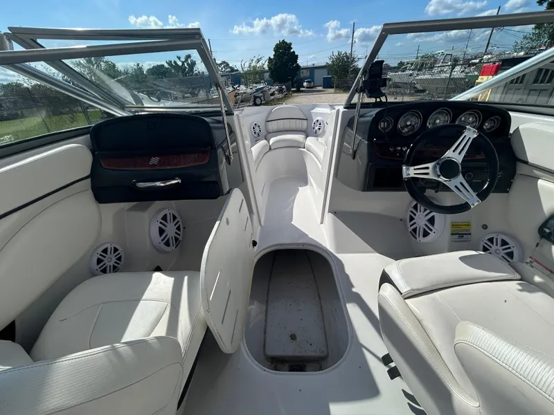 Slide: The Image of 2010 Four Winns H210 boat interior with white seating and steering wheel. - 23