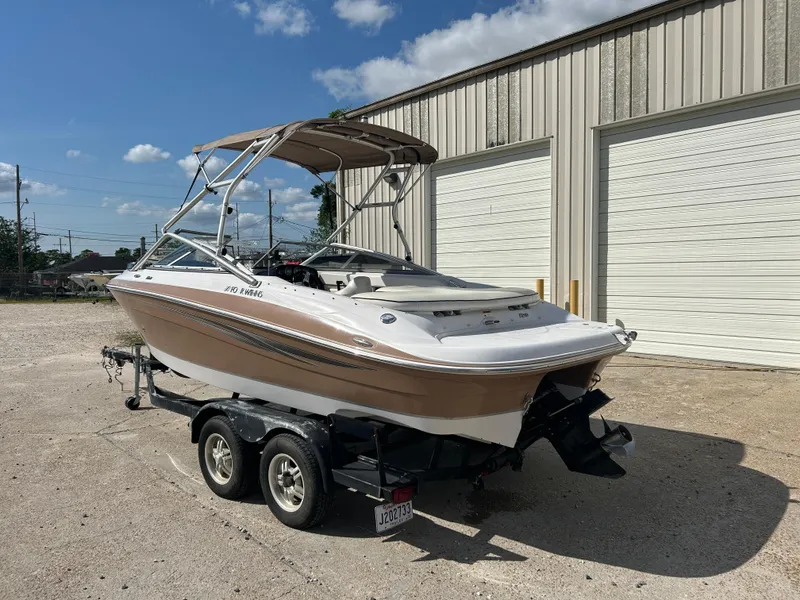Slide: The Image of 2010 Four Winns H210 boat on a trailer outside a warehouse. - 3