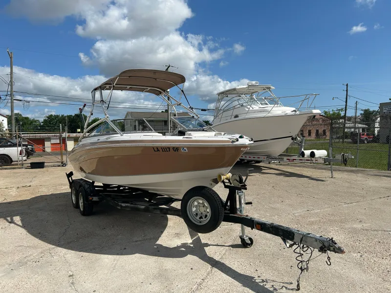 Slide: The Image of 2010 Four Winns H210 boat on a trailer in a parking lot. - 5