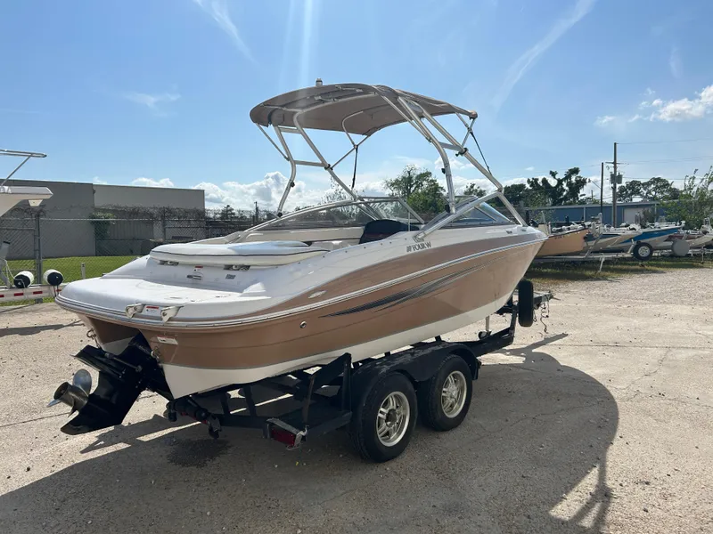 Slide: The Image of 2010 Four Winns H210 boat on a trailer in a sunny outdoor setting. - 7