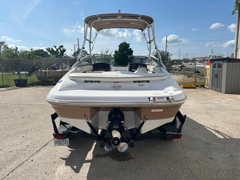 Slide: The Image of 2010 Four Winns H210 boat, rear view, parked outdoors on a sunny day. - 8