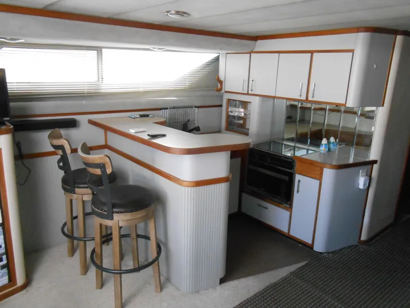 Slide: The Image of 1988 Cruisers Yachts 4280 Express Bridge interior with kitchen and bar area. - 11