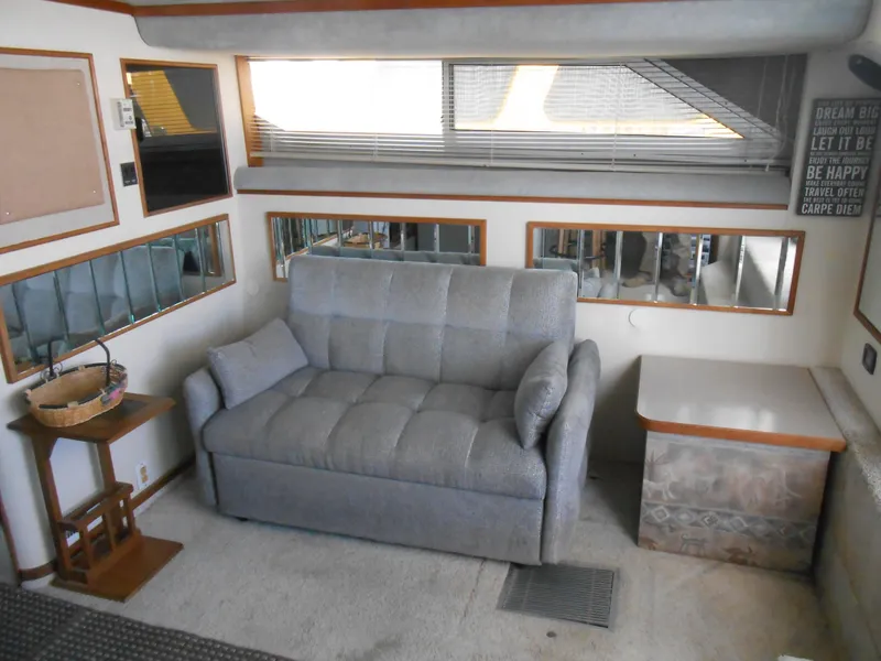 Slide: The Image of Interior of 1988 Cruisers Yachts 4280 Express Bridge with gray sofa and side table. - 12