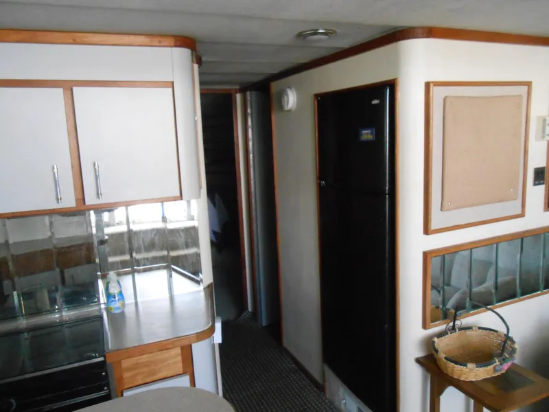 Slide: The Image of Interior of 1988 Cruisers Yachts 4280 Express Bridge, featuring kitchen and hallway. - 15
