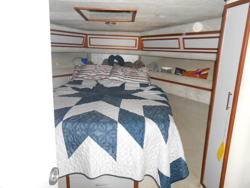Slide: The Image of 1988 Cruisers Yachts 4280 Express Bridge bedroom with star-patterned quilt. - 18
