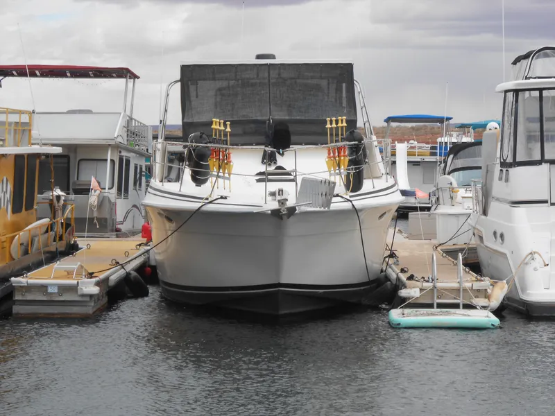 Slide: The Image of 1988 Cruisers Yachts 4280 Express Bridge docked at a marina. - 2