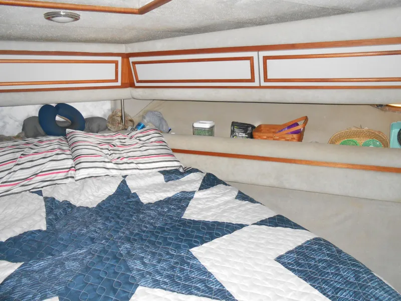 Slide: The Image of 1988 Cruisers Yachts 4280 Express Bridge cabin with bed and storage shelves. - 21