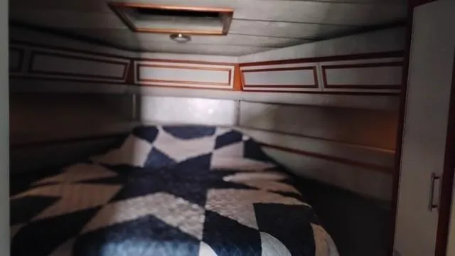 Slide: The Image of 1988 Cruisers Yachts 4280 Express Bridge cabin with geometric quilted bedspread. - 22