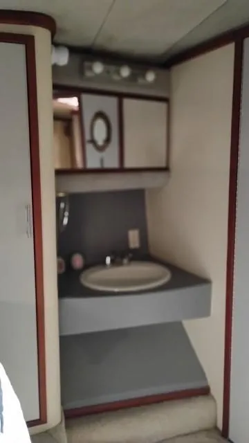 Slide: The Image of 1988 Cruisers Yachts 4280 Express Bridge bathroom with sink and mirror. - 31