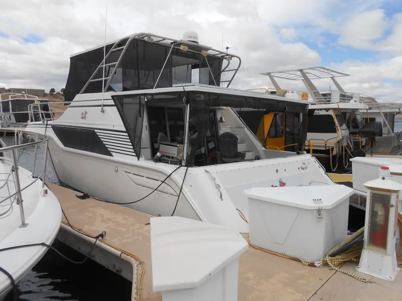 Slide: The Image of 1988 Cruisers Yachts 4280 Express Bridge docked at a marina. - 4