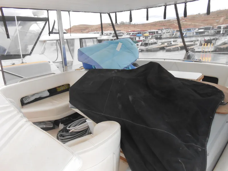 Slide: The Image of 1988 Cruisers Yachts 4280 Express Bridge interior with covered seating area at marina. - 5