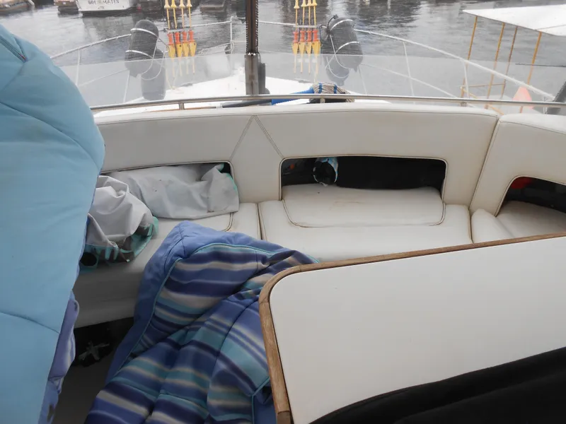 Slide: The Image of Interior seating area of 1988 Cruisers Yachts 4280 Express Bridge with cushions and blankets. - 9