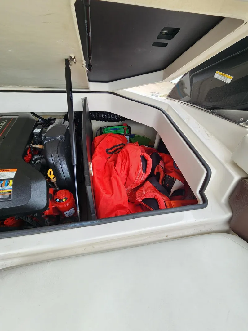 Slide: The Image of Storage compartment of a 2016 Regal 2100 Bowrider with life jackets and engine components. - 11