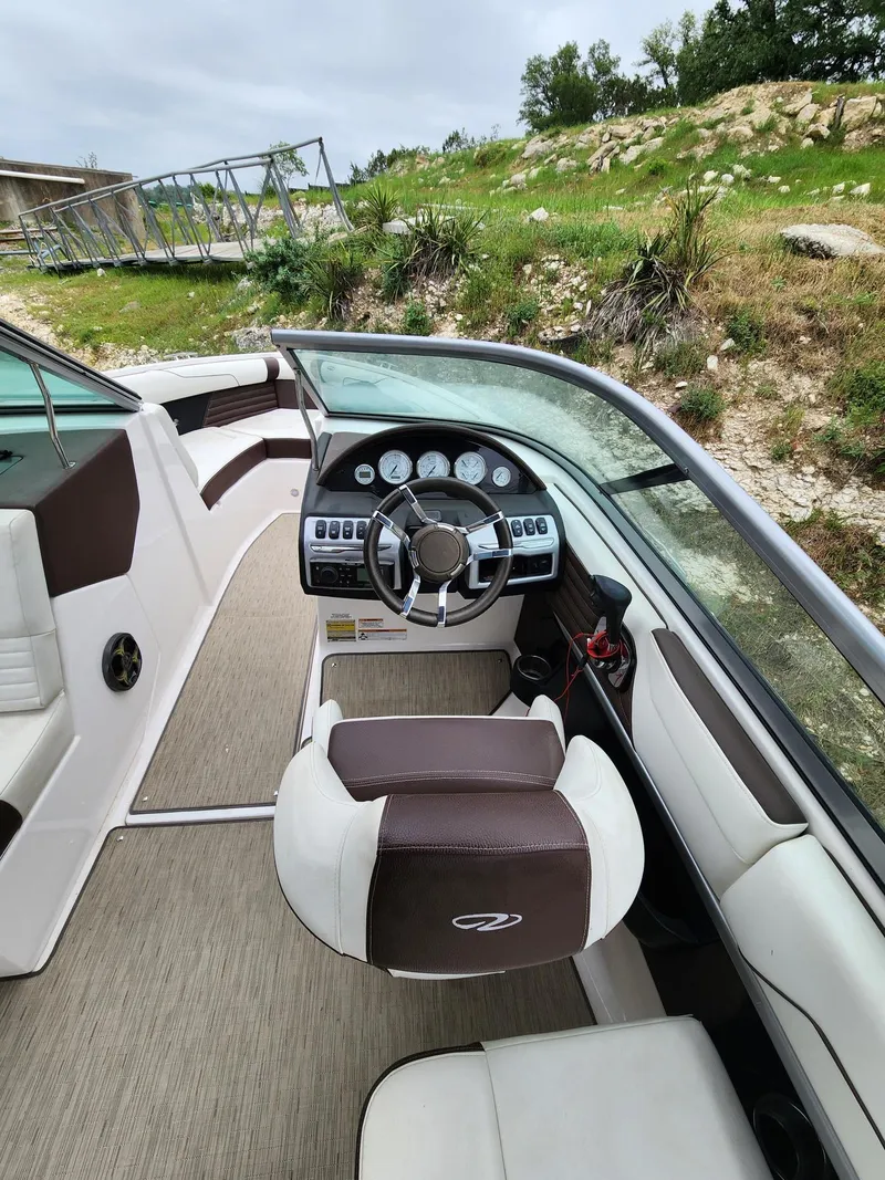 Slide: The Image of 2016 Regal 2100 Bowrider boat interior with steering wheel and seating. - 14