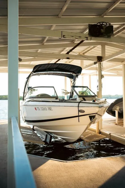 Slide: The Image of 2016 Regal 2100 Bowrider boat docked in a covered marina. - 17