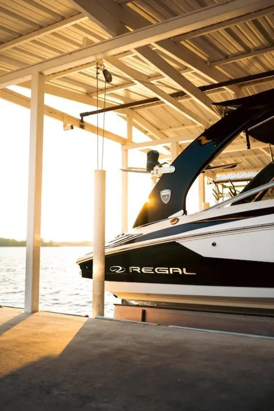 Slide: The Image of 2016 Regal 2100 Bowrider docked at sunset under a covered structure. - 19