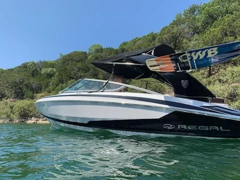 Slide: The Image of 2016 Regal 2100 Bowrider on water, surrounded by lush greenery. - 23