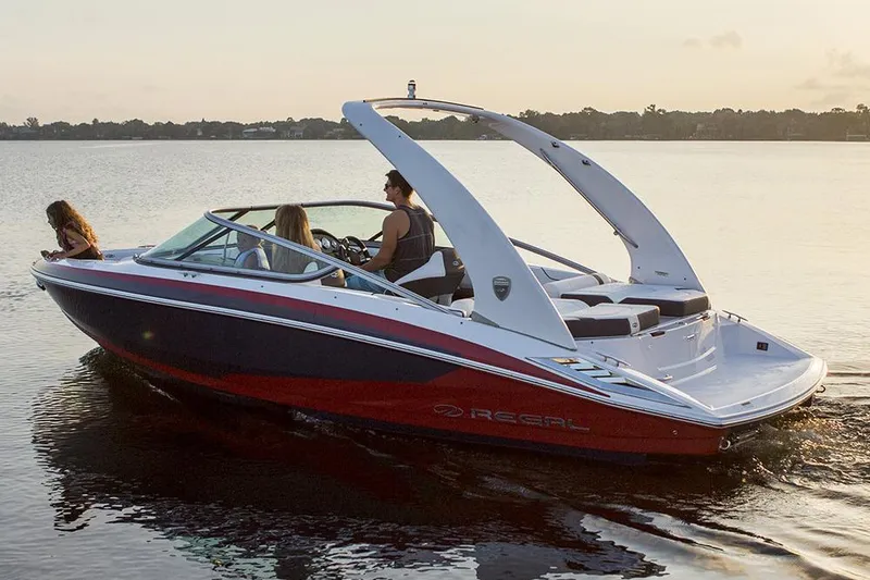 Slide: The Image of 2016 Regal 2100 Bowrider boat cruising on a calm lake at sunset. - 25