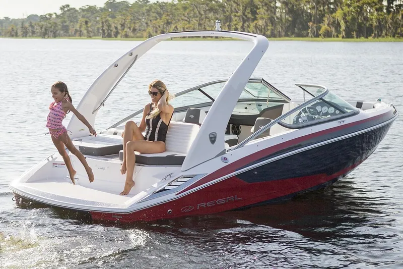 Slide: The Image of 2016 Regal 2100 Bowrider boat on a lake with people enjoying the water. - 26