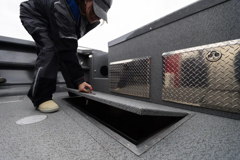 Slide: The Image of Person opening storage compartment on 2024 Spartan 240 Maximus Pro boat. - 12