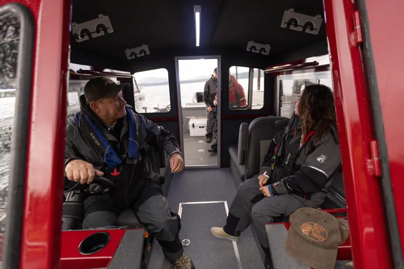 Slide: The Image of Interior of 2024 Spartan 240 Maximus Pro boat with passengers in black jackets. - 15